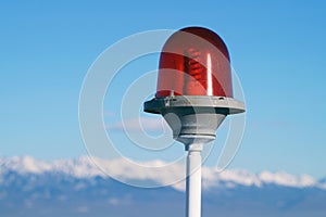 Signal lamp on the background of mountains and blue sky