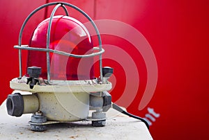 The signal lamp. Industrial red signal lamp on a red background. The concept of security.