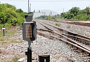 Signal lamp shunting railroad tracks beside the railway