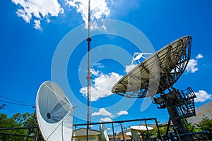 Signal Tower and Sky satellite dish are large and the clouds are white as a backdrop, high telecommunication signal, wireless