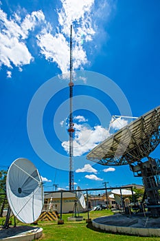 Signal Tower and Sky satellite dish are large and the clouds are white as a backdrop, high telecommunication signal, wireless