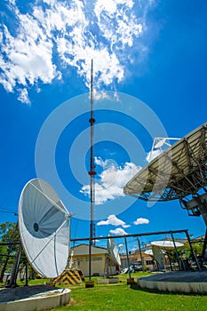 Signal Tower and Sky satellite dish are large and the clouds are white as a backdrop, high telecommunication signal, wireless