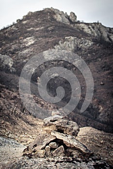 Signaling monolith on a road with burned fields in the background as a result of a fire photo