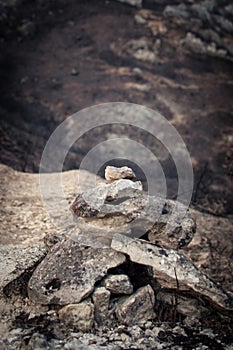 Signaling monolith on a road with burned fields in the background as a result of a fire photo