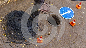 Signalman worker pulling an electric cable through the city well