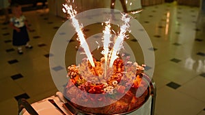 Signature dish of restaurant big bread kalach pastries with fried stew on grill burning candles fireworks