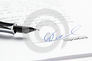 Signature in ink in the contract. Sheet of paper and pen close-up