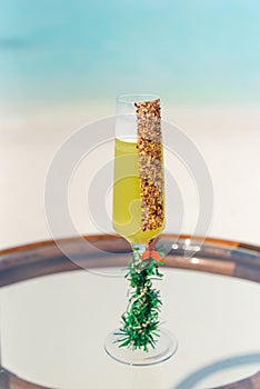 Signature new year celebration tropical cocktail on the glass table at the beach with ocean