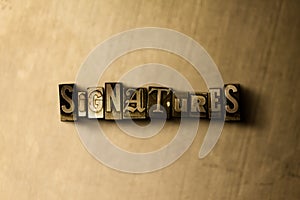 SIGNATURES - close-up of grungy vintage typeset word on metal backdrop