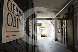 Signboard and yellow car in inner yard of building on Panska street