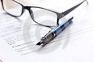 Signing the contract with pen and glasses in business work on office desk