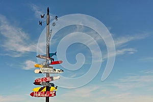 Signpost with colorful directional signs and distances to different towns