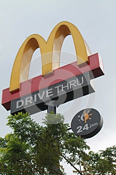 Signpost with Mc Donald's fast food restaurant logo