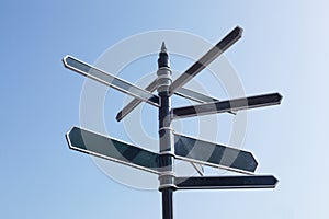 Signpost Pointing In Many Directions Against Blue Sky photo