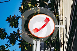 Signpost with red telephone on a street