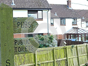 A signpost in Sampford Peverell, Devon, directing towards the pubs and toilets