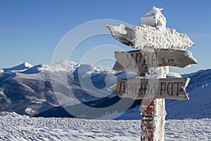 Signpost in snowy mountains. The inscription on the table "Dragobrat, Urda photo