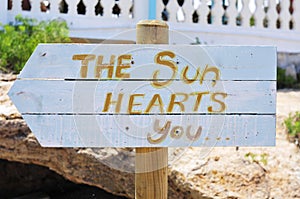 Signpost with the text the sun hearts you