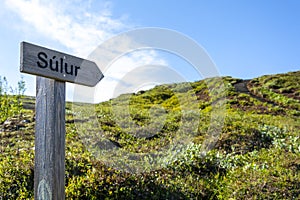 Signpost on the top of a mountain with a blue sky in the background