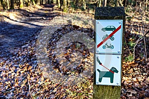 Signs indicating: dogs on leash and cars, bicycles and motorcycles prohibited