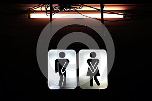 Signs night bathroom, old toilet symbol male and female in the night background