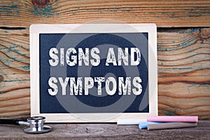 Signs and symptoms. Chalkboard on a wooden background