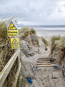 Signs warning of Sudden Drop and Steep Slope at Dooey beach by Lettermacaward in County Donegal - Ireland.