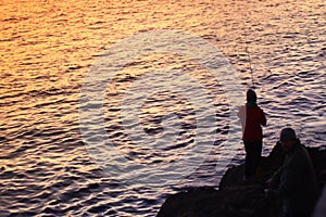 Sihlouette of a man fishing in the sea at sunset. Palma, Majorca photo
