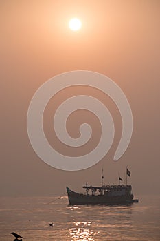 Sihouette of boat sailing in sunset in Mumbai beach at killeshwar temple at madh