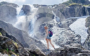 Siklawa waterfall on a beautiful sunny day. Young traveler woman traveler.