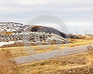 Silage piles on a large dairy farm covered with plastic and cut tires to prevent spoilage. Selective focus, background blur and fo