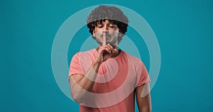 Silence gesture - Portrait of young Indian man closed his mouth with imaginary zipper and throwing the key