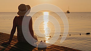 Silence and pacification in the early morning on the sea pier, the girl enjoys loneliness