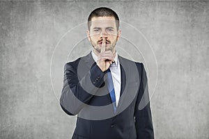 Silence please, businessman doing silence sign