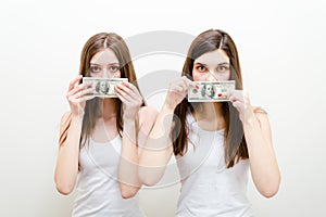 Silenced by money. Two beautiful young women showing money