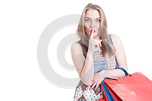 Silent concept with stylish beautiful woman doing shush gesture photo