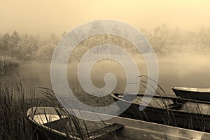 Silent morning with boats on a foggy lake