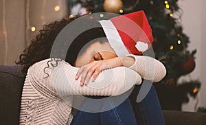 Silent night and Christmas just doesnt feel right. Shot of a young woman looking sad during Christmas at home.