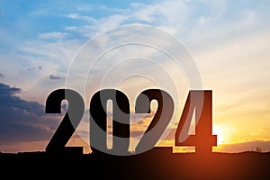 Silhouette 2024 with sunset sky at mountain and number like 2024 abstract background.