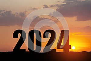 Silhouette 2024 with sunset sky at mountain and number like 2024 abstract background.