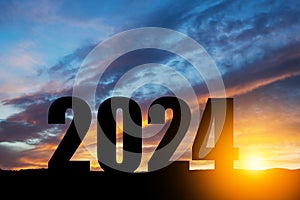 Silhouette 2024 with sunset sky at mountain and number like 2024 abstract background.