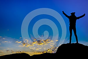 Silhouette achievements successful arm up girl is on top of hill celebrating success with sunset