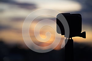 Silhouette Action camera in front of the twilight sky, Technology and Nature concept