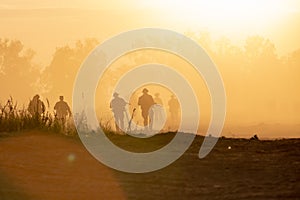 Silhouette action soldiers walking hold weapons the background is smoke and sunset and white balance ship effect dark