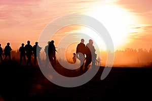 Silhouette action soldiers walking hold weapons the background is smoke and sunset and white balance ship effect dark