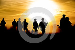 Silhouette action soldiers walking hold weapons the background is smoke and sunset and white balance ship effect dark