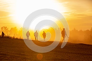 Silhouette action soldiers walking hold weapons the background is smoke and sunset and white balance ship effect dark