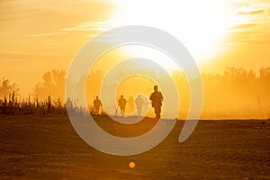 Silhouette action soldiers walking hold weapons the background is smoke and sunset and white balance ship effect dark