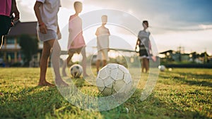 Silhouette action sport outdoors of diversity of kids having fun playing soccer football for exercise in community rural area unde