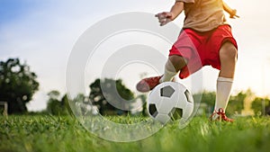 Silhouette action sport outdoors of a group of kids having fun playing soccer football for exercise in community rural area under